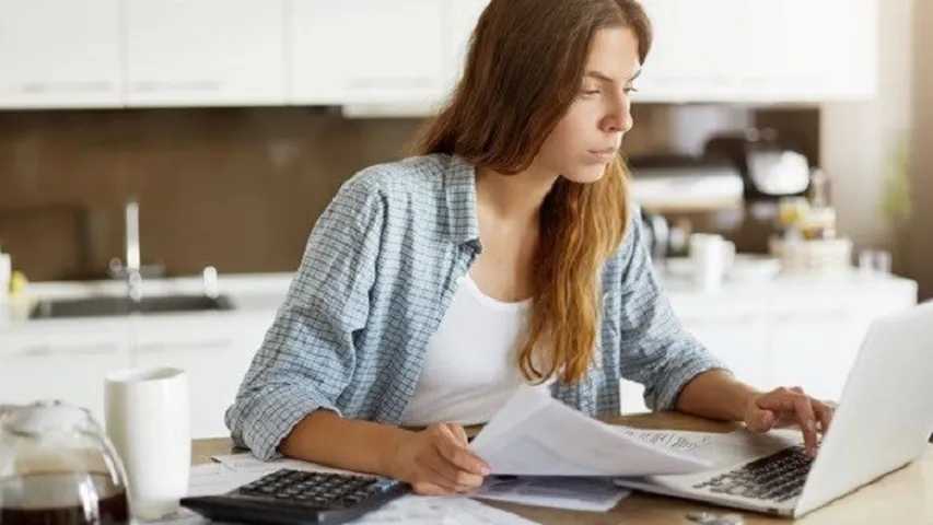 Mujer revisando las facturas de la luz y los cargos en cuenta bancaria. (Foto: Freepik)